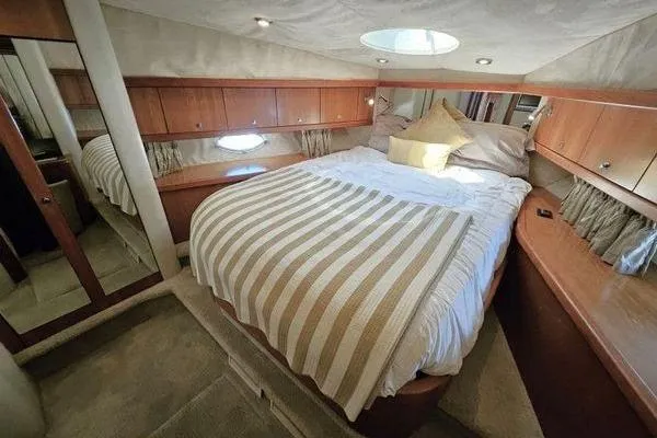 Slide: The Image of Luxurious cabin interior of 2005 Sunseeker Manhattan 66 yacht with cozy bed and wood paneling. - 50