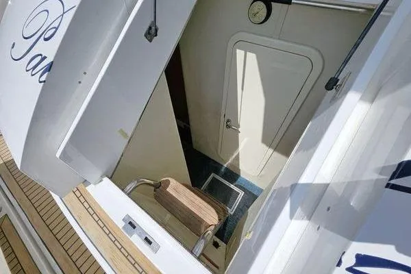 Slide: The Image of Sunseeker Manhattan 66 yacht interior entrance, featuring a wooden step and white door, 2005 model. - 62