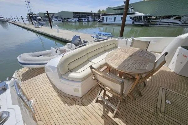Slide: The Image of Luxurious Sunseeker Manhattan 66 yacht deck with seating and table, docked at marina. - 7