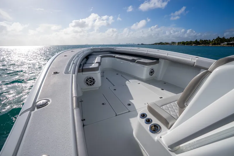 Slide: The Image of 2024 Yellowfin 39 Offshore boat deck with seating, cruising on open water under a clear sky. - 22