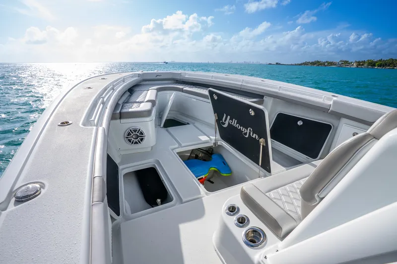 Slide: The Image of 2024 Yellowfin 39 Offshore boat interior with seating, storage, and ocean view. - 23