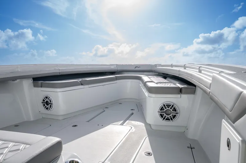 Slide: The Image of 2024 Yellowfin 39 Offshore boat interior with cushioned seating under a clear blue sky. - 27