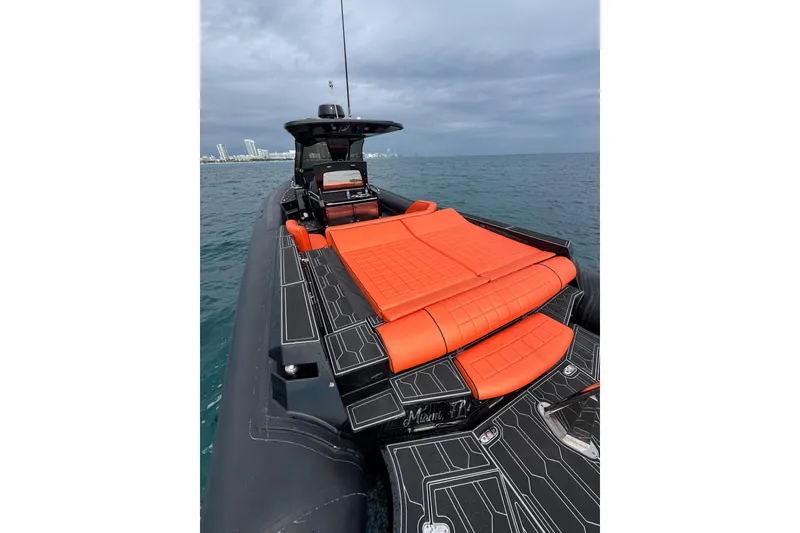 Slide: The Image of 2017 MV Marine 40 boat with orange seating, cruising on open water under cloudy skies. - 15