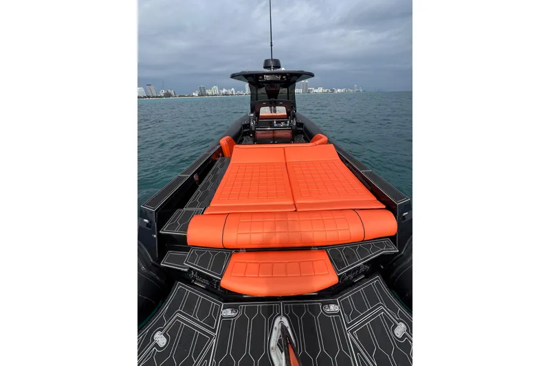 Slide: The Image of 2017 MV Marine 40 boat with orange seating, on the water, city skyline in background. - 17