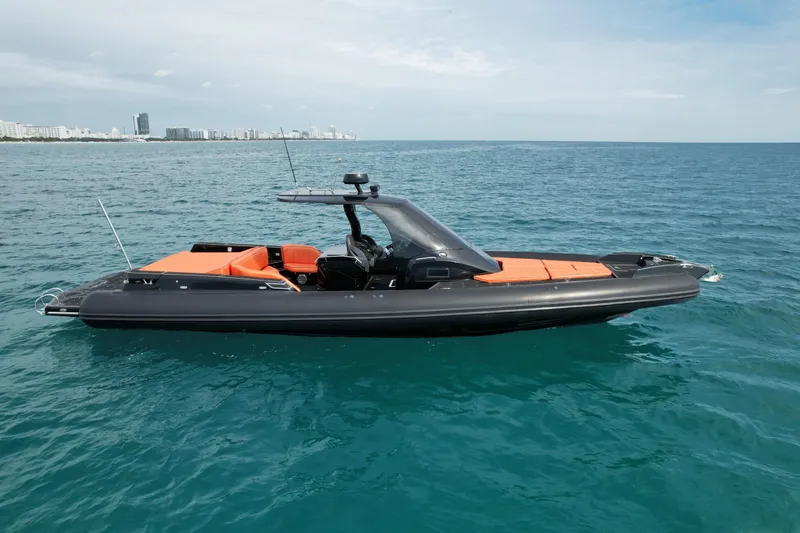 Slide: The Image of 2017 MV Marine 40 boat on calm ocean waters, city skyline in background. - 5