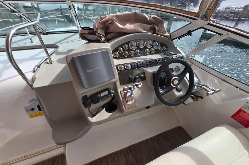 Slide: The Image of Helm of 2002 Cruisers Yachts 3372 Express with steering wheel and navigation controls. - 12