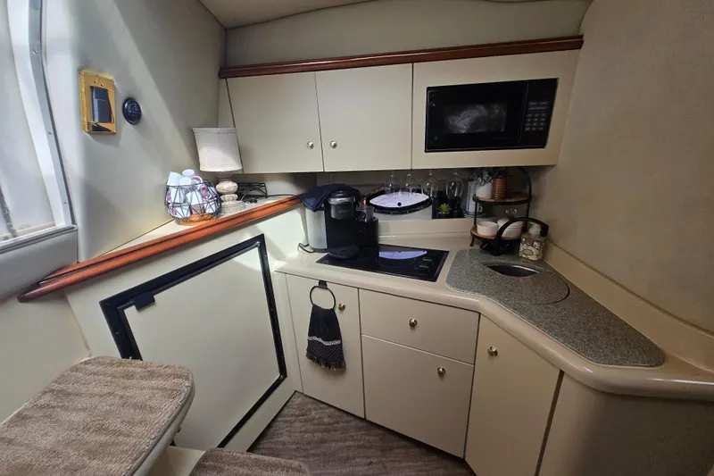 Slide: The Image of 2002 Cruisers Yachts 3372 Express galley with microwave, sink, and coffee maker. - 23