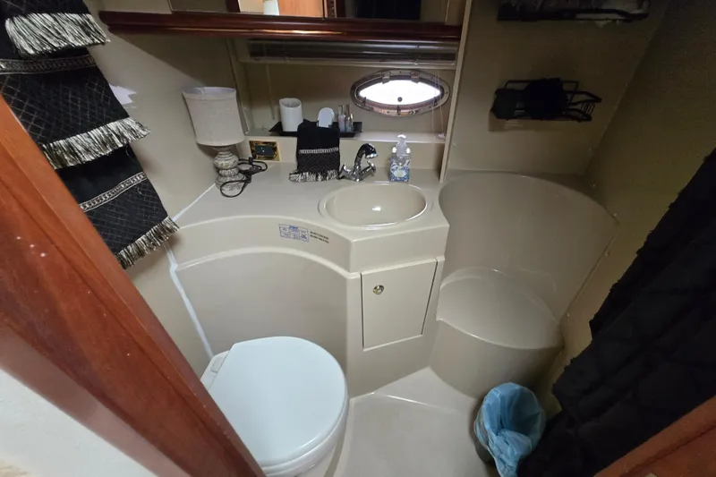 Slide: The Image of 2002 Cruisers Yachts 3372 Express bathroom with sink, toilet, and storage. - 25