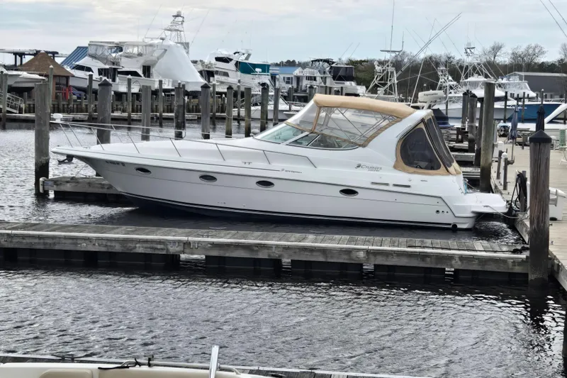Slide: The Image of 2002 Cruisers Yachts 3372 Express docked at a marina, surrounded by other boats. - 3