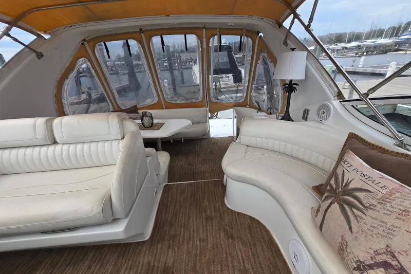Slide: The Image of Interior of 2002 Cruisers Yachts 3372 Express with white seating and marina view. - 4