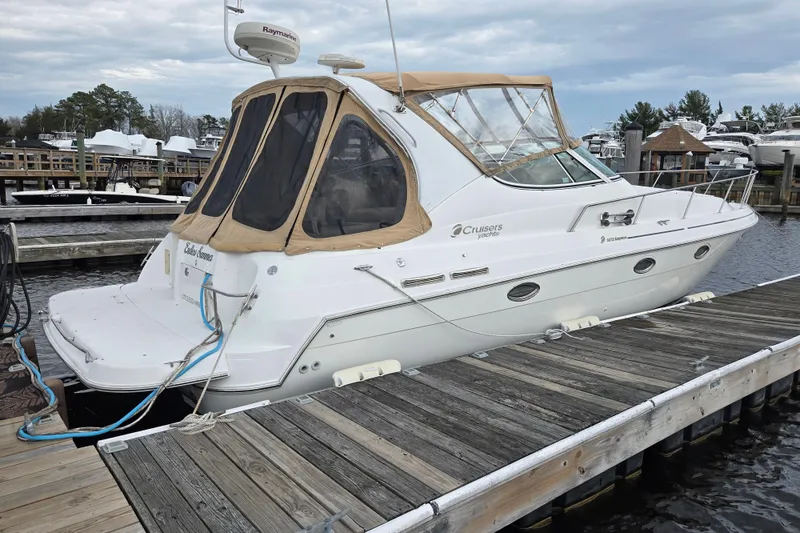 Slide: The Image of 2002 Cruisers Yachts 3372 Express docked at marina, featuring tan canopy and sleek design. - 5