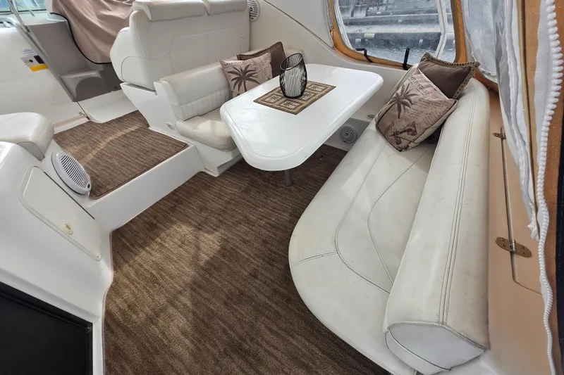 Slide: The Image of Interior of 2002 Cruisers Yachts 3372 Express with white seating and decorative pillows. - 6