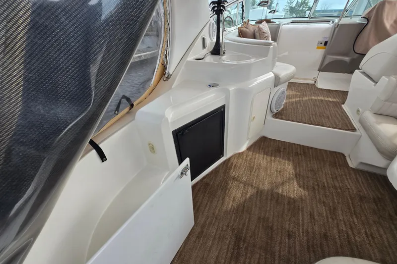 Slide: The Image of 2002 Cruisers Yachts 3372 Express interior with seating, sink, and carpeted flooring. - 8