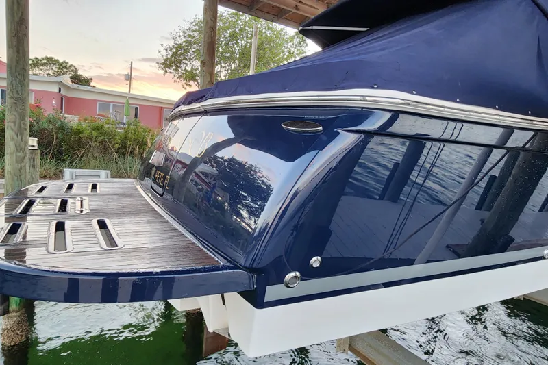 Slide: The Image of 2014 Tiara Yachts 3100 Coronet docked, showcasing sleek blue exterior and swim platform. - 10