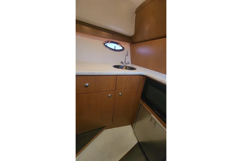 Slide: The Image of 2014 Tiara Yachts 3100 Coronet interior kitchenette with sink and cabinetry. - 15