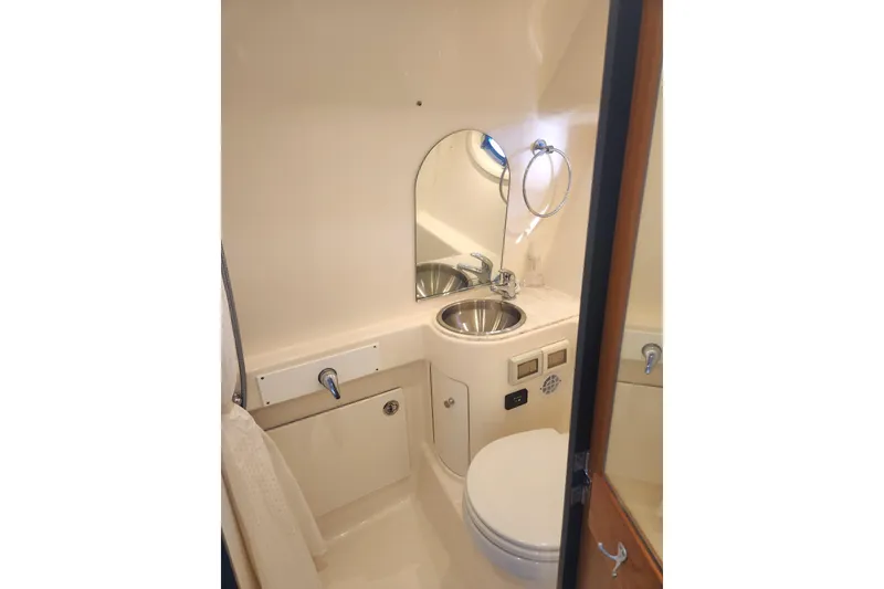 Slide: The Image of 2014 Tiara Yachts 3100 Coronet bathroom with sink, mirror, and toilet. - 17
