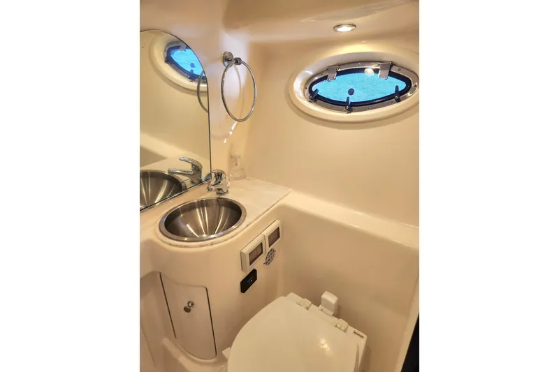 Slide: The Image of Luxurious 2014 Tiara Yachts 3100 Coronet bathroom with stainless steel sink and porthole window. - 18
