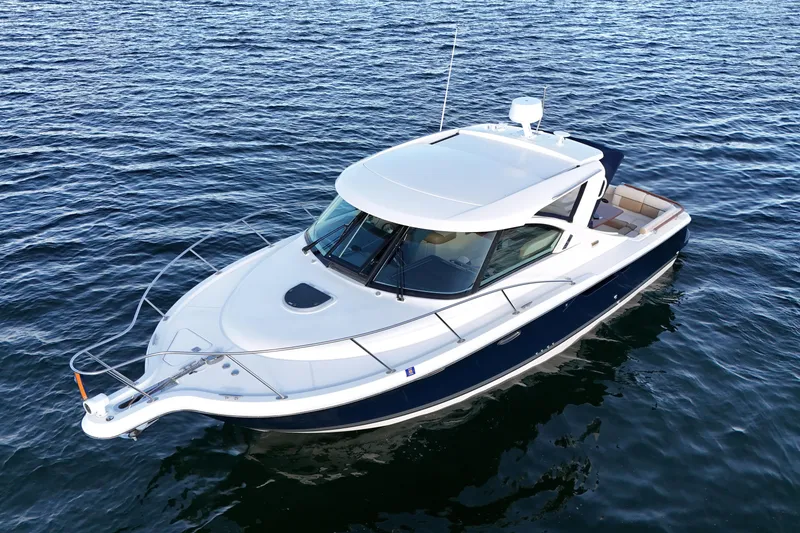 Slide: The Image of 2014 Tiara Yachts 3100 Coronet cruising on open water, showcasing sleek design and elegance. - 2