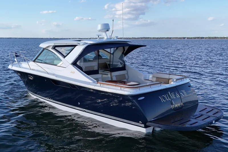 Slide: The Image of 2014 Tiara Yachts 3100 Coronet cruising on open water under a clear sky. - 3