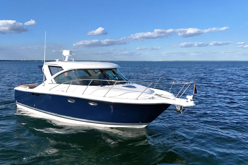 Slide: The Image of 2014 Tiara Yachts 3100 Coronet cruising on open water under a clear blue sky. - 5