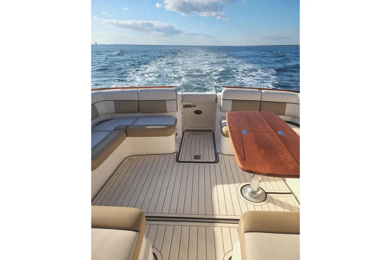 Slide: The Image of 2014 Tiara Yachts 3100 Coronet boat interior with ocean view and wooden table. - 7