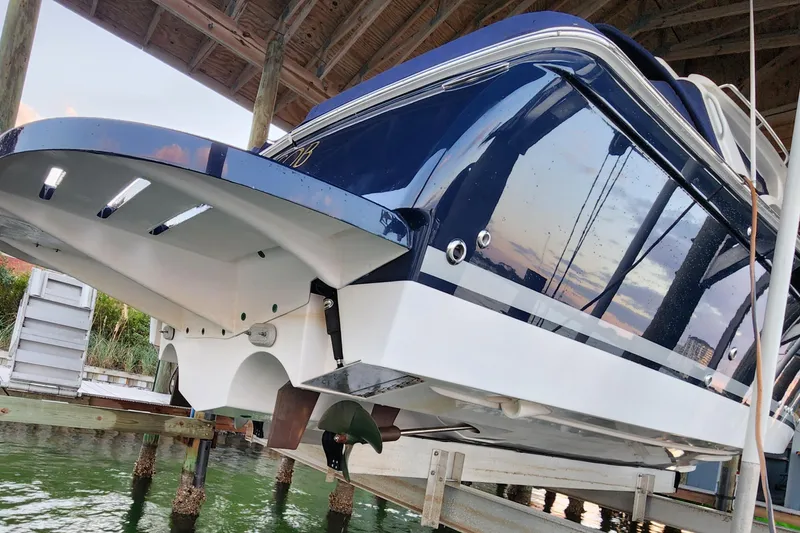 Slide: The Image of 2014 Tiara Yachts 3100 Coronet on lift, reflecting sunset over water. - 9