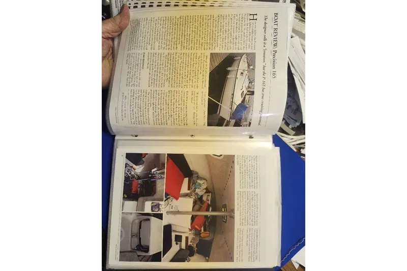Slide: The Image of Open book displaying a boat review article for the 1996 Precision 165 model. - 19