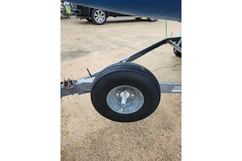 Slide: The Image of Trailer wheel of a 1996 Precision 165 boat on concrete surface. - 5