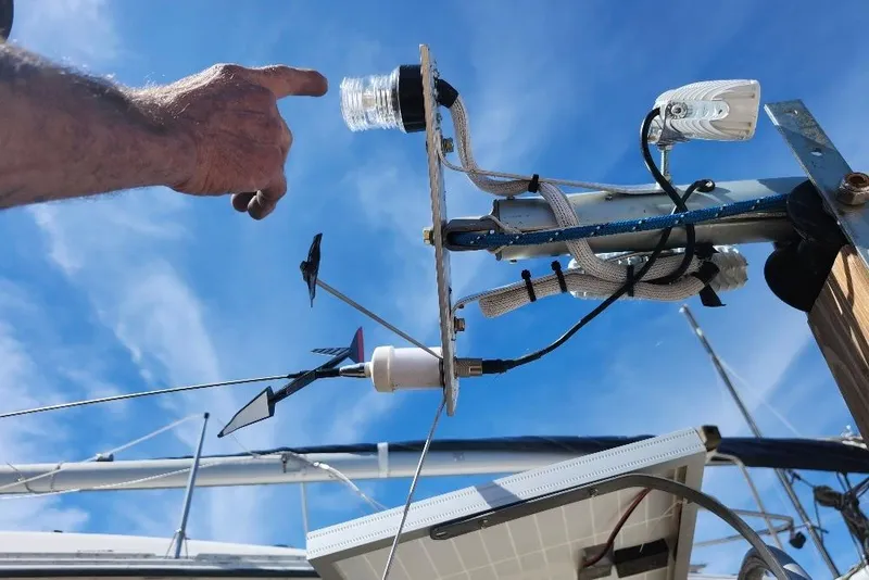Slide: The Image of Hand pointing at DIY weather instrument setup on a boat under a clear blue sky. - 9
