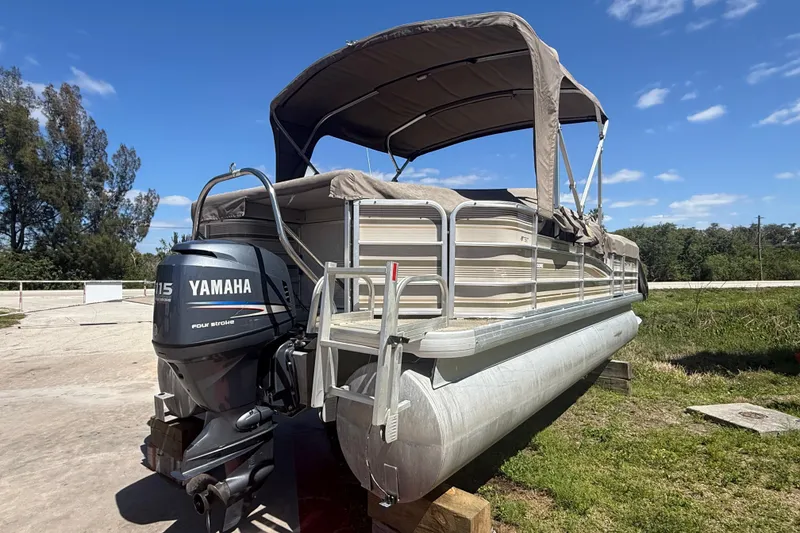The Image of 2003 Godfrey 2200 RE pontoon boat with Yamaha 115 outboard motor, parked outdoors. - 0