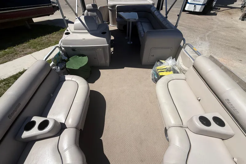 Slide: The Image of Interior of a 2003 Godfrey 2200 RE pontoon boat with beige seating and cup holders. - 14