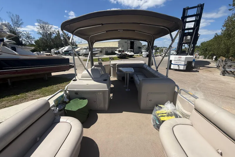Slide: The Image of 2003 Godfrey 2200 RE pontoon boat with canopy, docked in a sunny marina setting. - 15