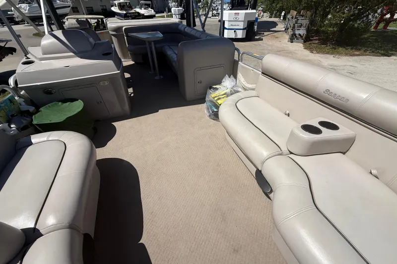 Slide: The Image of Interior of a 2003 Godfrey 2200 RE pontoon boat with beige seating and cup holders. - 16