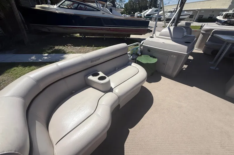 Slide: The Image of 2003 Godfrey 2200 RE boat interior with beige seating and cup holders. - 17
