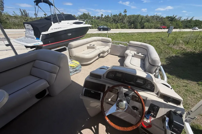 Slide: The Image of Interior of a 2003 Godfrey 2200 RE pontoon boat with plush seating and steering console. - 18