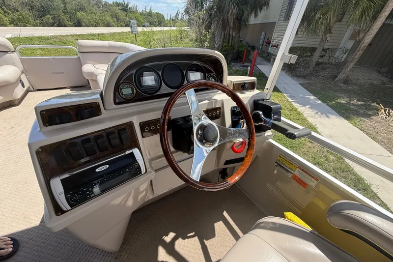 Slide: The Image of 2003 Godfrey 2200 RE boat dashboard with steering wheel and control panel. - 19