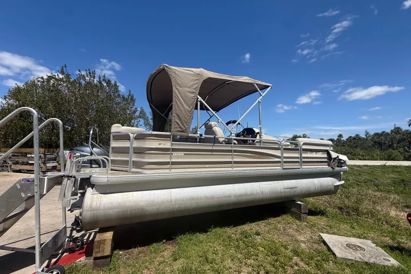 Slide: The Image of 2003 Godfrey 2200 RE pontoon boat on trailer under clear blue sky. - 2