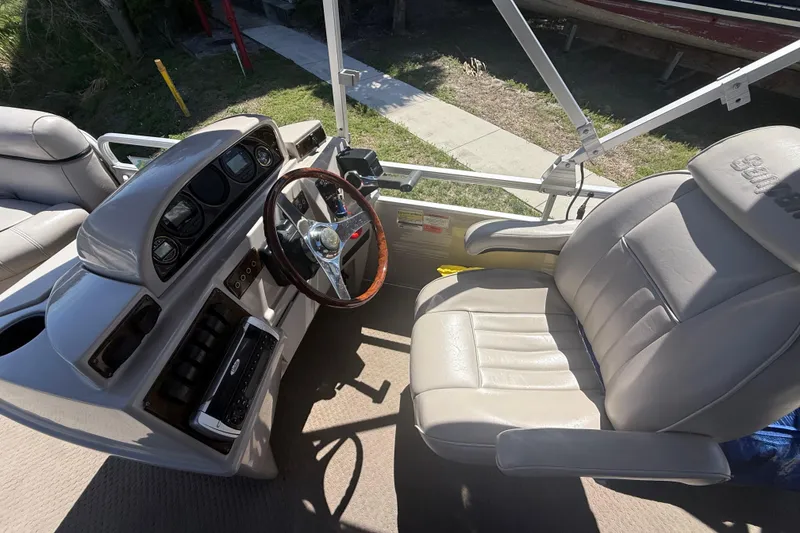 Slide: The Image of Interior of a 2003 Godfrey 2200 RE boat with steering wheel and captain's chair. - 20