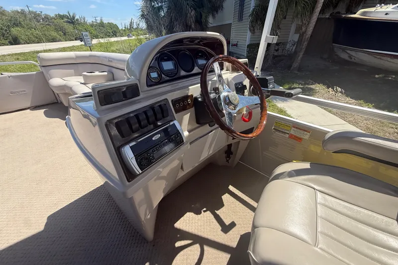 Slide: The Image of Interior of a 2003 Godfrey 2200 RE boat with steering wheel and dashboard controls. - 21