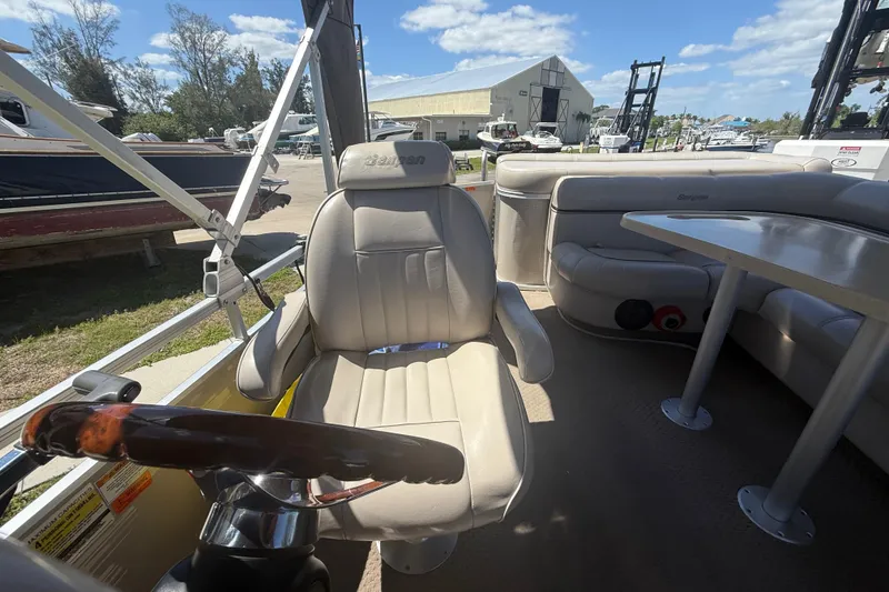 Slide: The Image of Interior of a 2003 Godfrey 2200 RE boat with beige seating and steering wheel. - 22