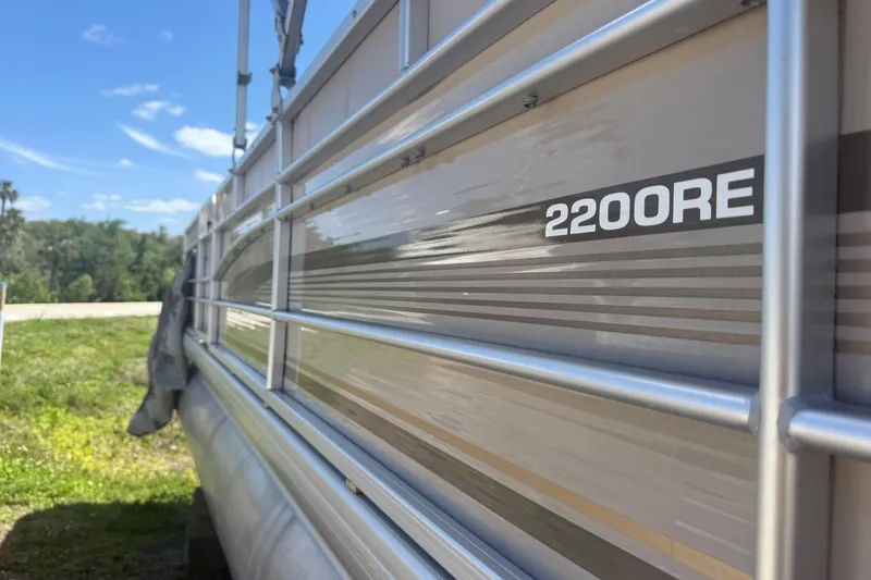Slide: The Image of Side view of a 2003 Godfrey 2200 RE pontoon boat under a clear blue sky. - 3