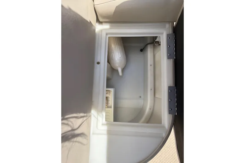 Slide: The Image of Storage compartment in a 2003 Godfrey 2200 RE boat, featuring a white interior. - 33