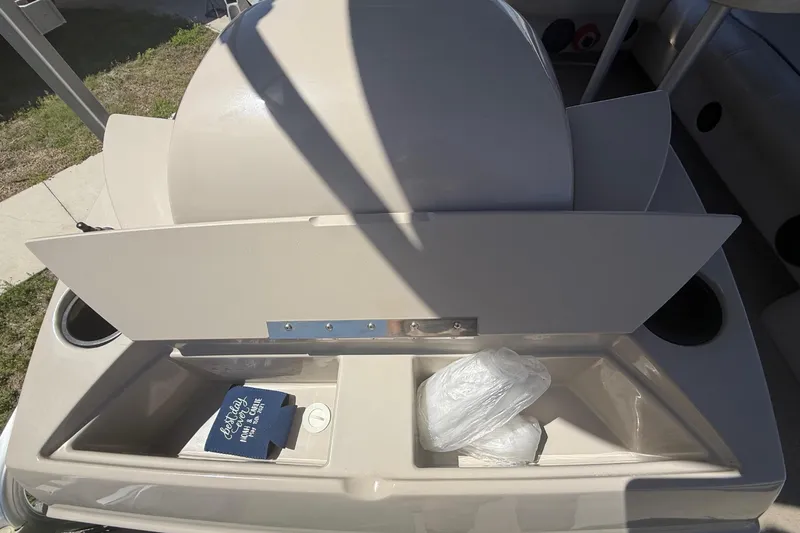 Slide: The Image of 2003 Godfrey 2200 RE boat storage compartment with cup holders and items inside. - 35