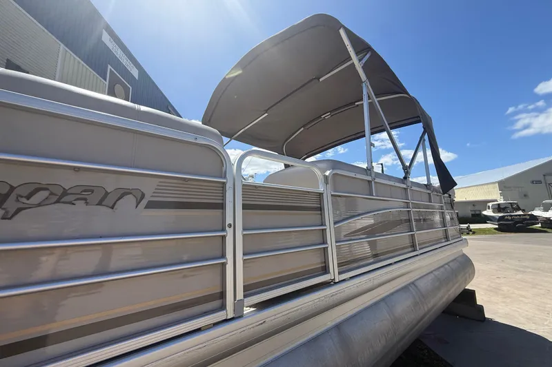 Slide: The Image of 2003 Godfrey 2200 RE pontoon boat with canopy, parked outdoors under blue sky. - 4