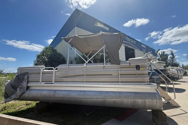 Slide: The Image of 2003 Godfrey 2200 RE pontoon boat with canopy, parked outdoors under a clear blue sky. - 41