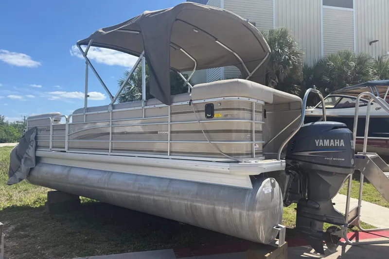 Slide: The Image of 2003 Godfrey 2200 RE pontoon boat with Yamaha motor, parked outdoors under blue sky. - 42