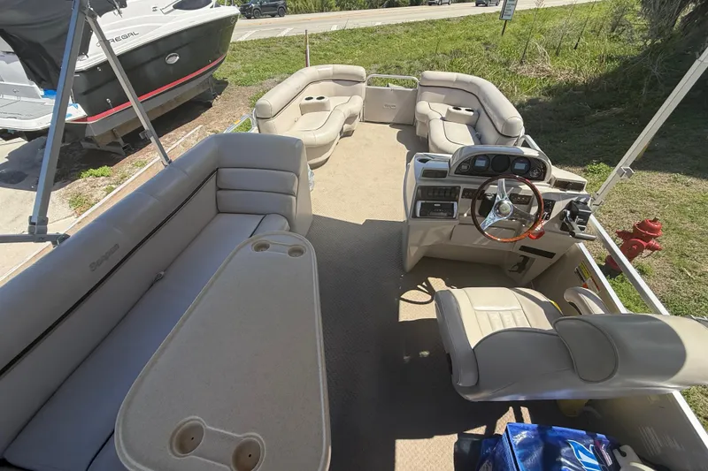 Slide: The Image of Interior of a 2003 Godfrey 2200 RE pontoon boat with beige seating and steering console. - 6