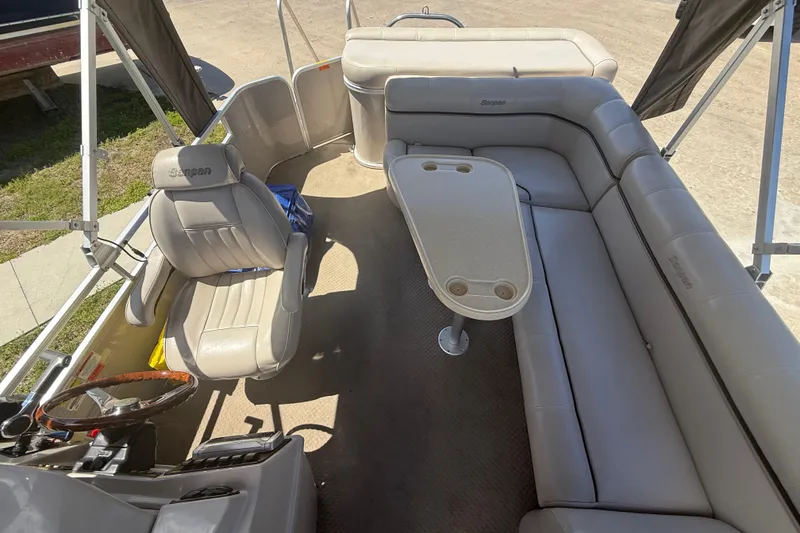 Slide: The Image of Interior of a 2003 Godfrey 2200 RE pontoon boat with beige seating and table. - 8