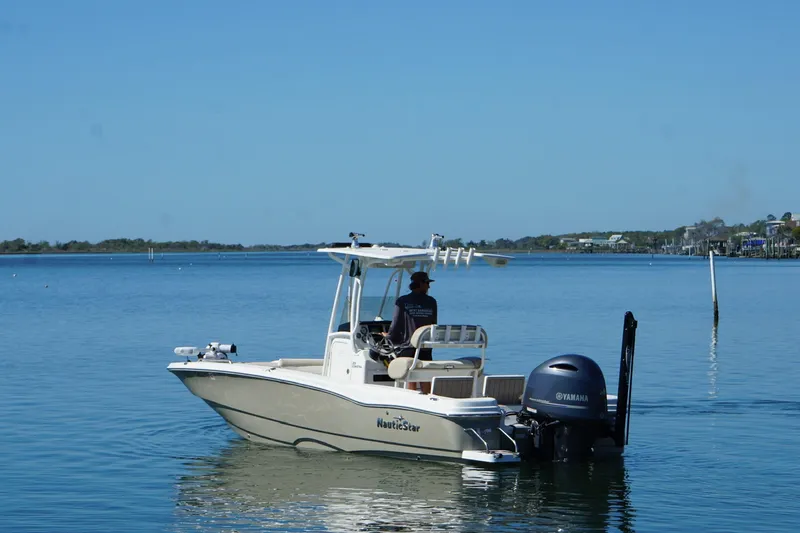 Slide: The Image of 2016 NauticStar 231 Coastal boat on calm water with Yamaha outboard motor. - 15