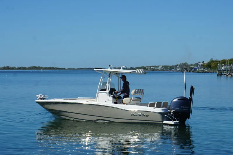 Slide: The Image of 2016 NauticStar 231 Coastal boat cruising on calm waters under clear blue sky. - 2